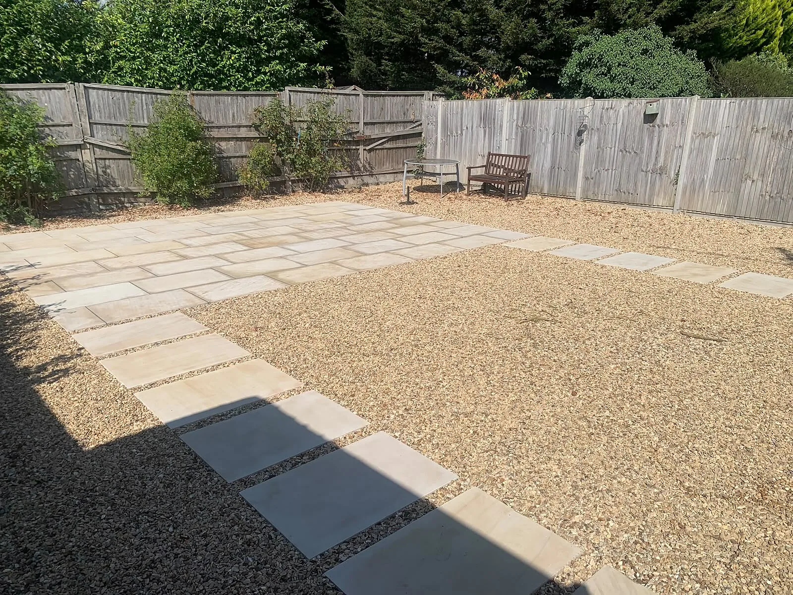Patio and gravel garden with slab stepping path beside a timber fence – Fines Landscaping, West Norfolk