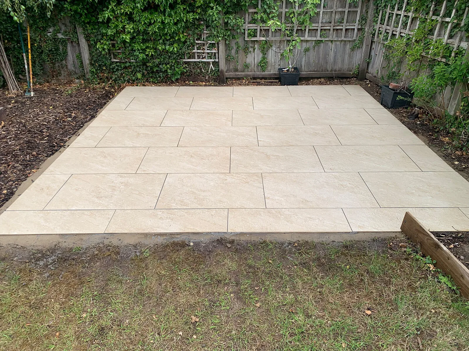 New sandstone-effect patio laid on a level base in a fenced West Norfolk garden