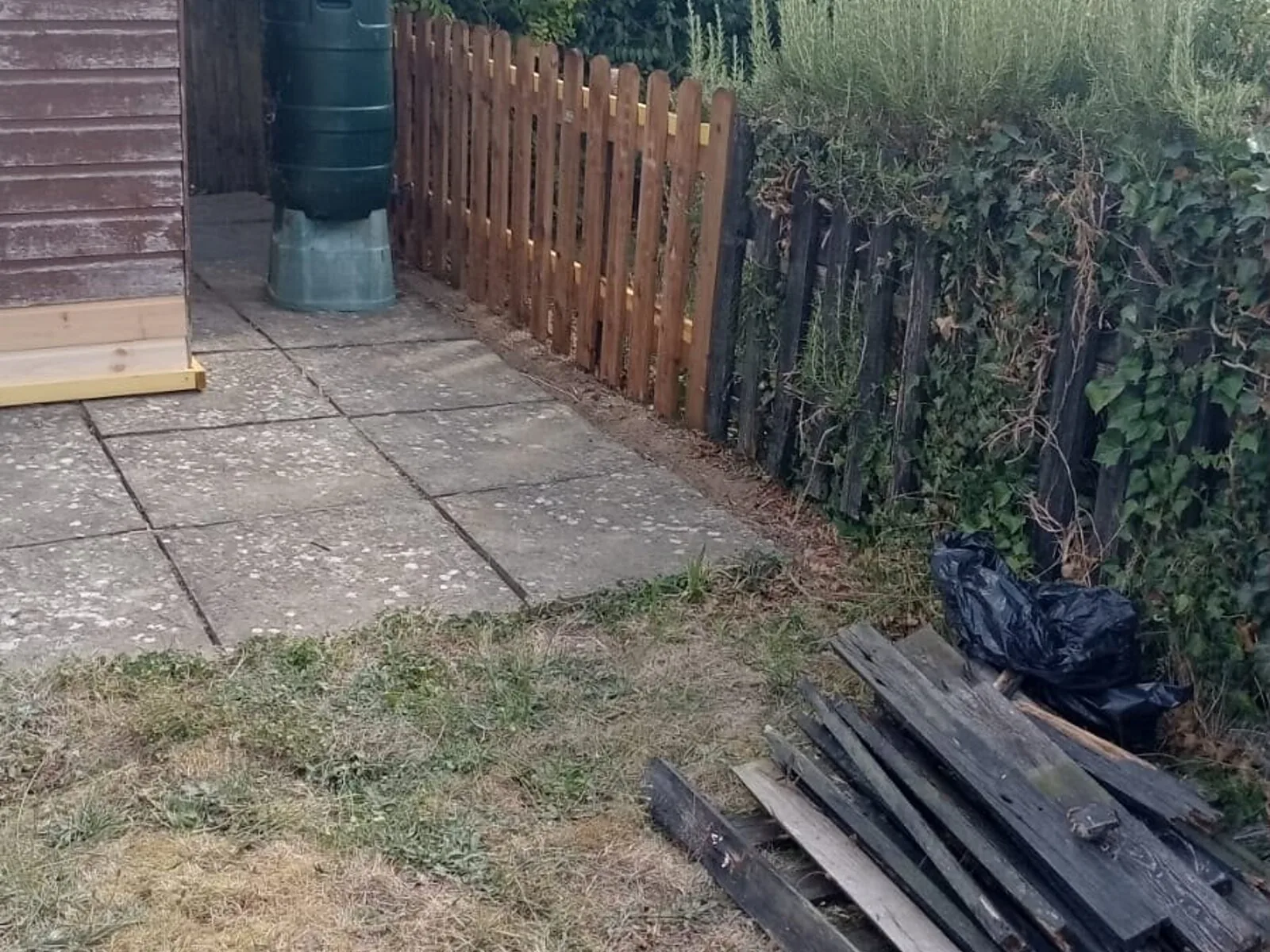 Picket fencing being fitted along a garden boundary – Fines Landscaping, West Norfolk