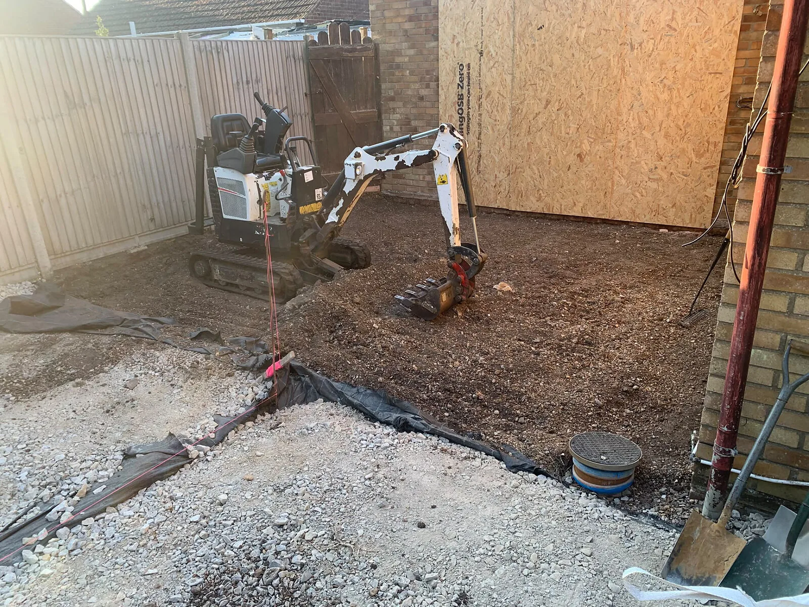 Mini digger excavating a garden for groundworks – Fines Landscaping, West Norfolk