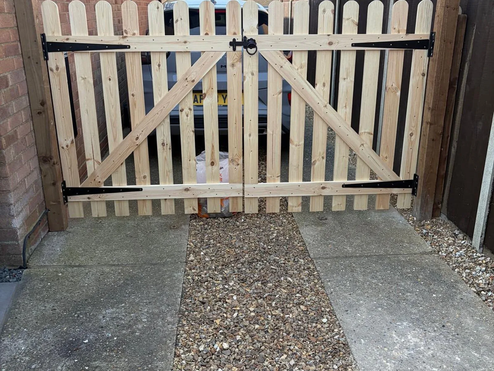 Double timber picket gates hung across a driveway entrance – Fines Landscaping, West Norfolk