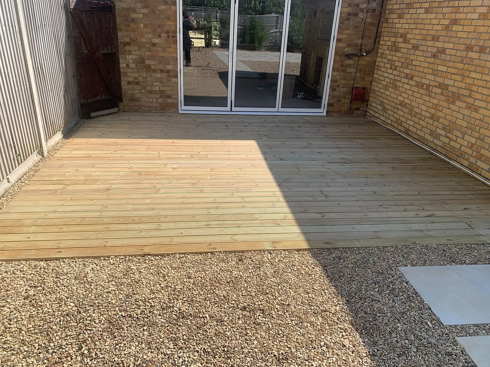 Ground-level timber decking outside bi-fold doors – Fines Landscaping, West Norfolk