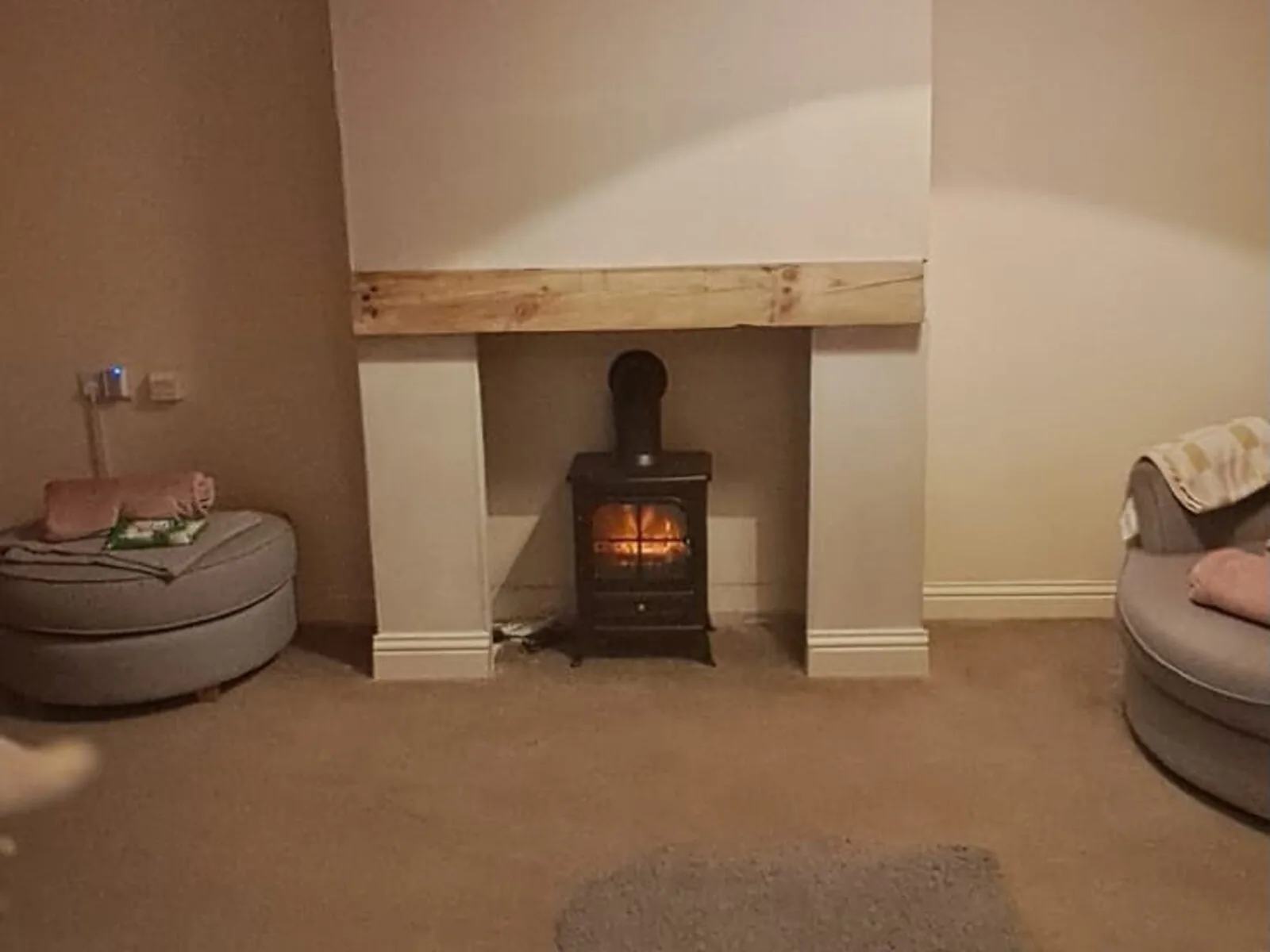 Finished fireplace surround with timber beam and log burner – Fines Landscaping, West Norfolk